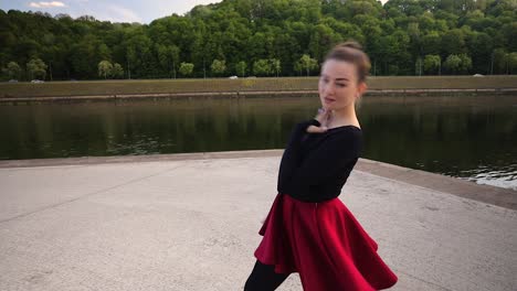 attractive caucasian dancer dancing in front of a river in a warm summer evening