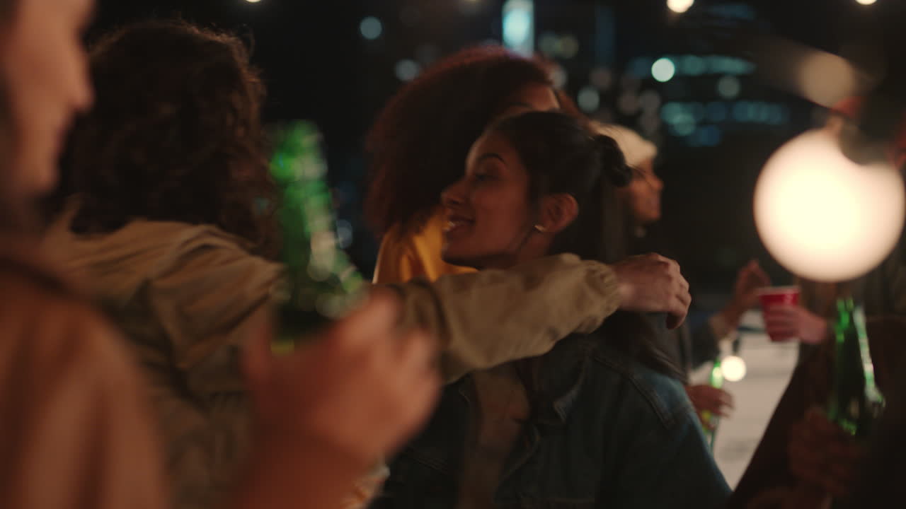 happy group of friends dancing to lively rooftop party music enjoying weekend celebration in urban city at night