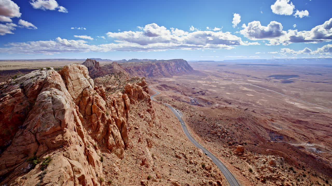 Dynamic aerial view hugging the towering mountain edge, unveiling the sheer vertical drop near Antelope Pass Vista en route to Page, Arizona.