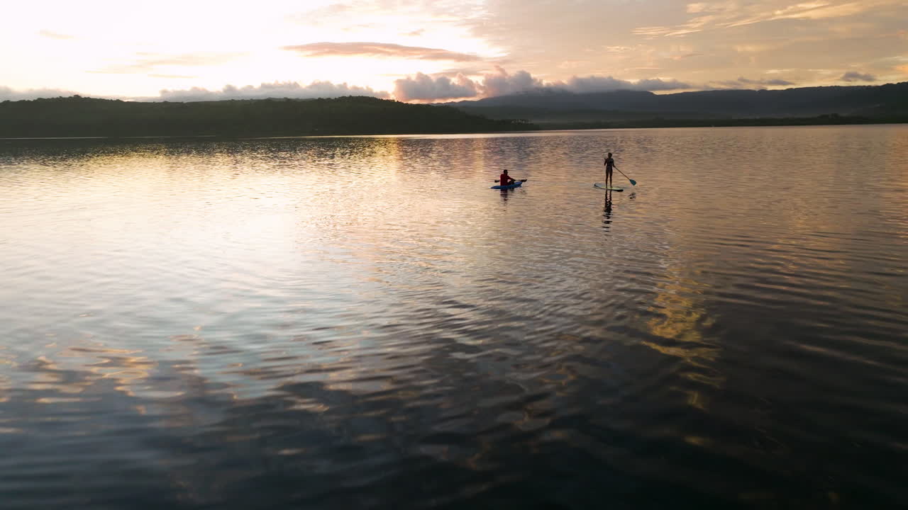 Drone riprende una coppia su paddleboard e kayak all'alba sull'isola di Moso, Efate Nord, Vanuatu