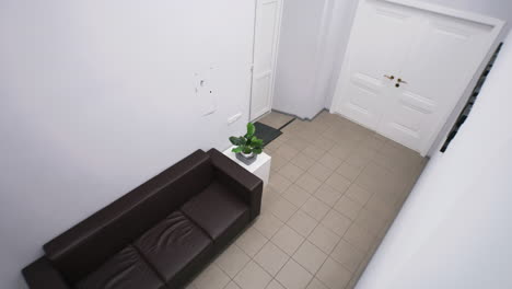 man in a modern white room with a sofa and double doors