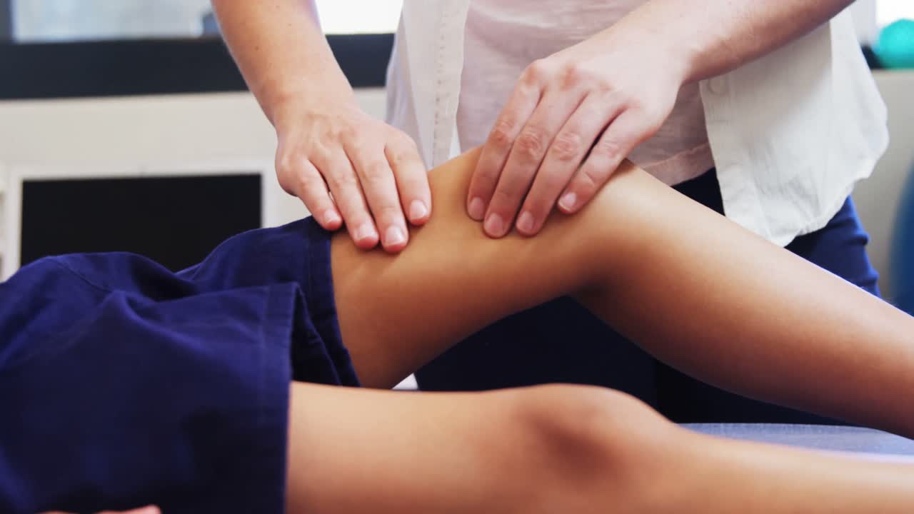 Physiotherapist giving physical therapy to the boy 4k