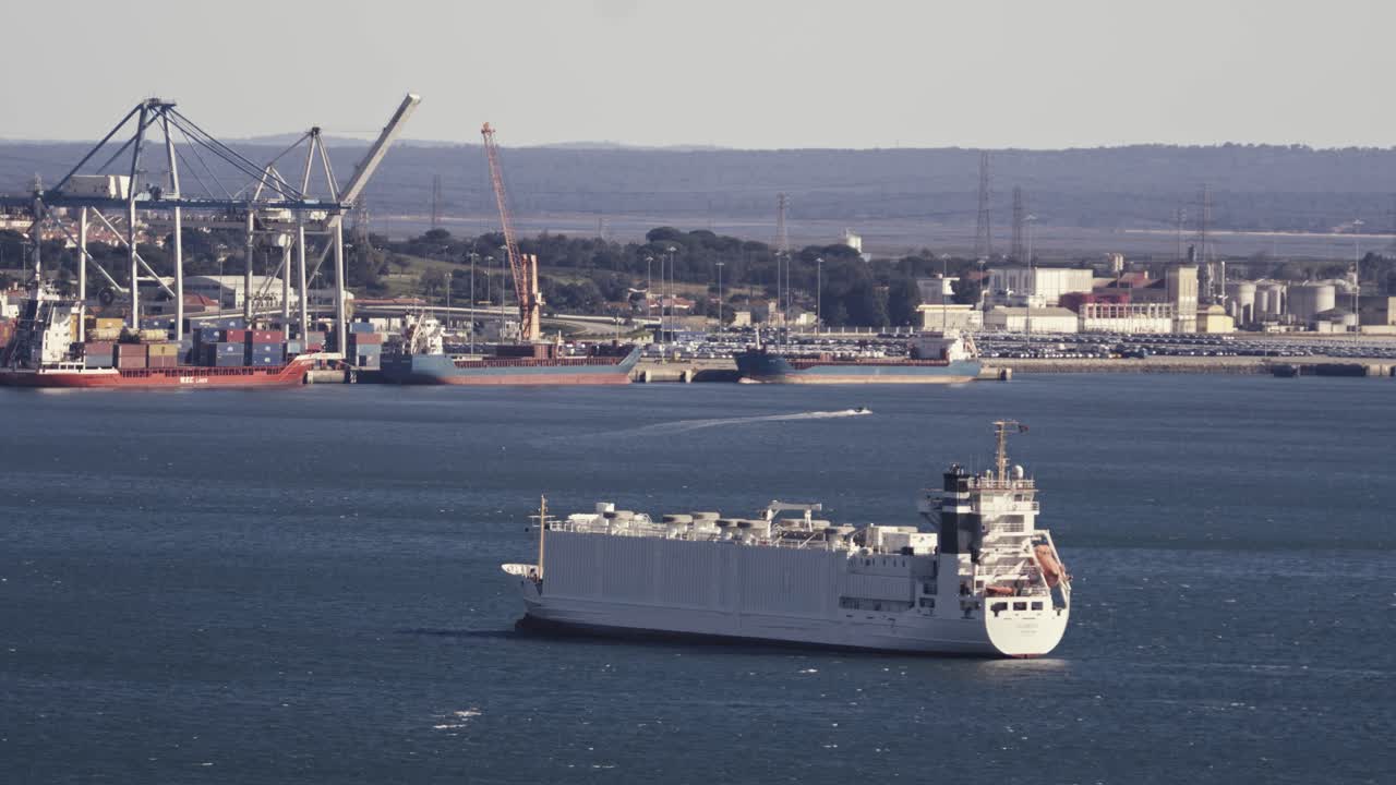 화물선은 대형 크레인이 기다리고 있는 항구에 천천히 도착합니다.