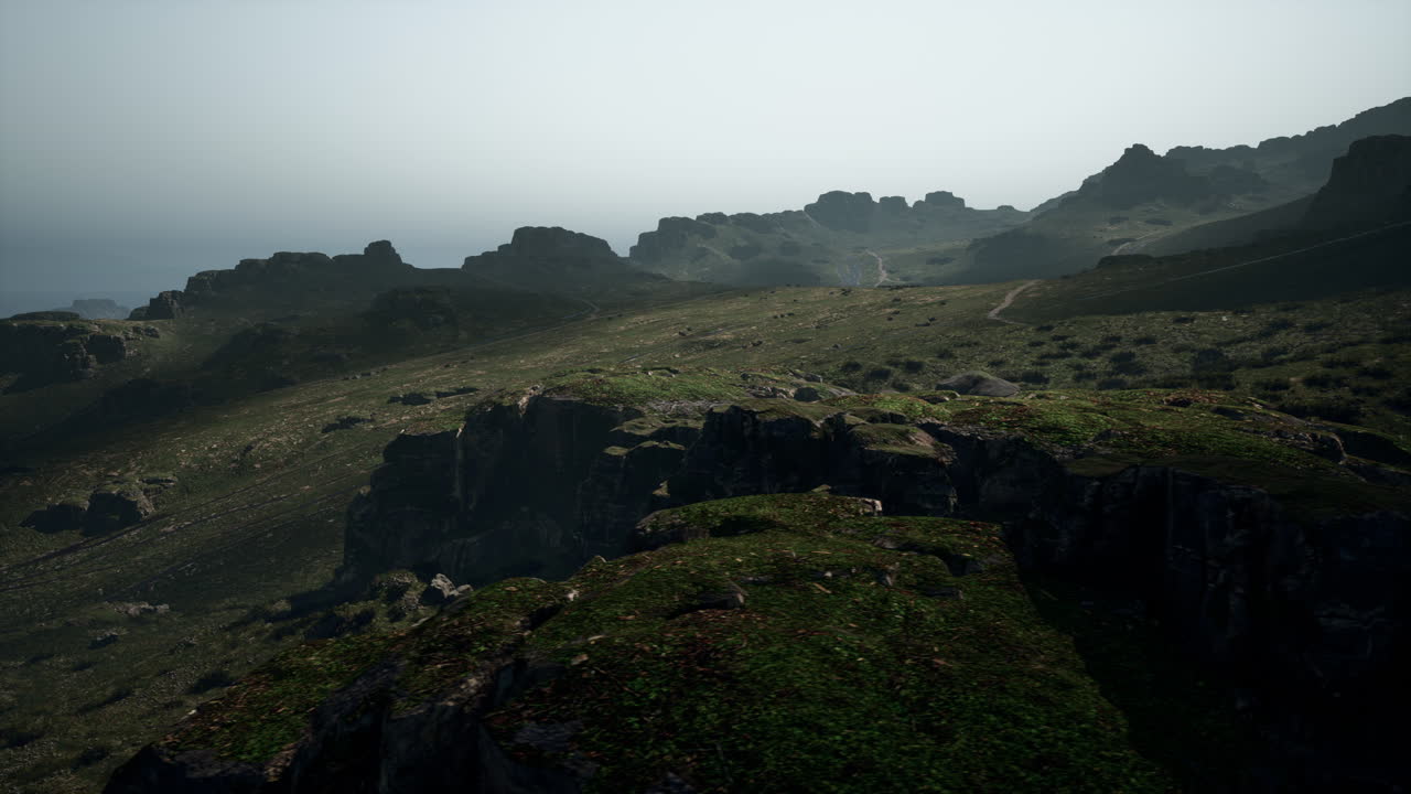 vista aérea de montañas y colinas con hierba verde y niebla