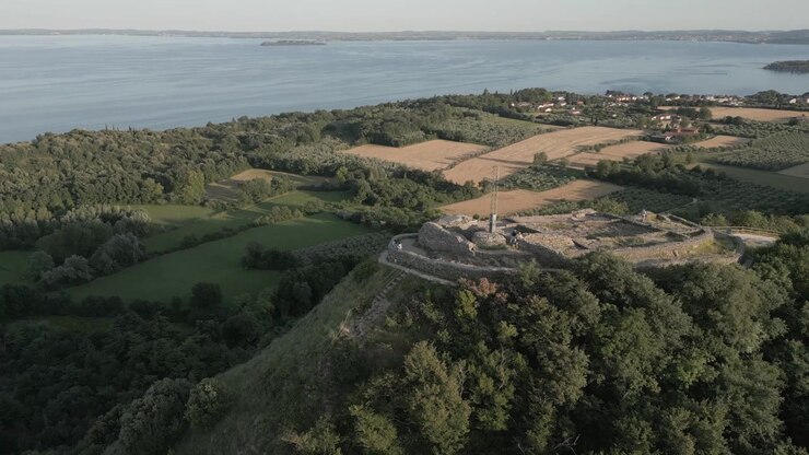 Ripresa con drone della Rocca di Manerba del Garda che domina la campagna e il Lago di Garda.