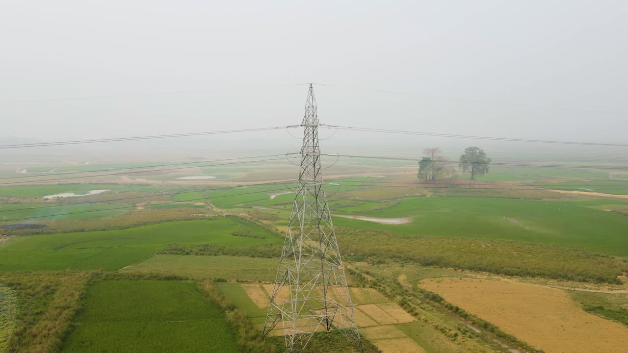 Et udzoomet billede fra en højspændingsmast i et tåget landskab, der viser industrialiseringen af landområderne og omfanget af vores energiinfrastruktur