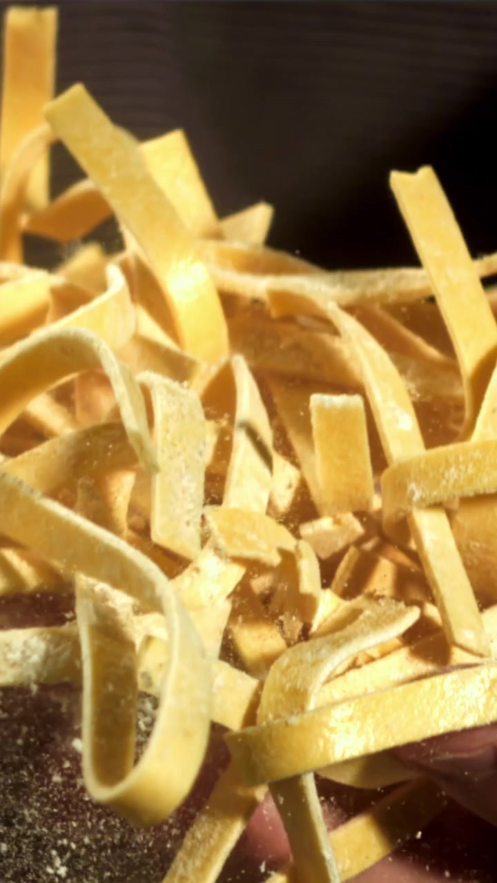 Fresh Tagliatelle Pasta Falling in Slow Motion with Flour Dust