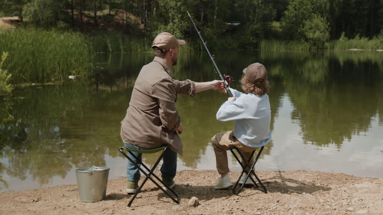 아버지와 아들이 호수에서 시를 하고 있다