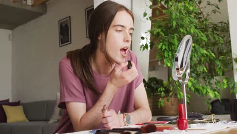 mujer transgénero caucásica no binaria haciendo maquillaje