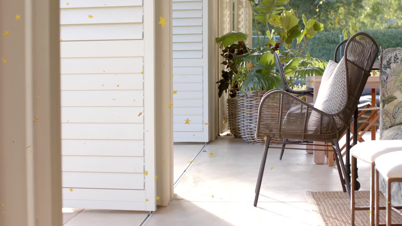 Camera panning right to reveal wicker chair and woven planter, leaves moving, yellow stars drifting