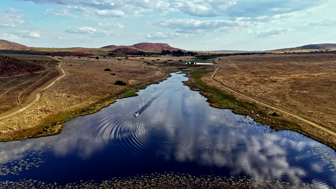 High angle drone view high-speed power boat motoring on isolated lake