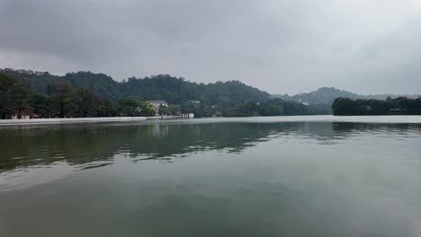 4k video of kandy lake in sri lanka with mountains in the background