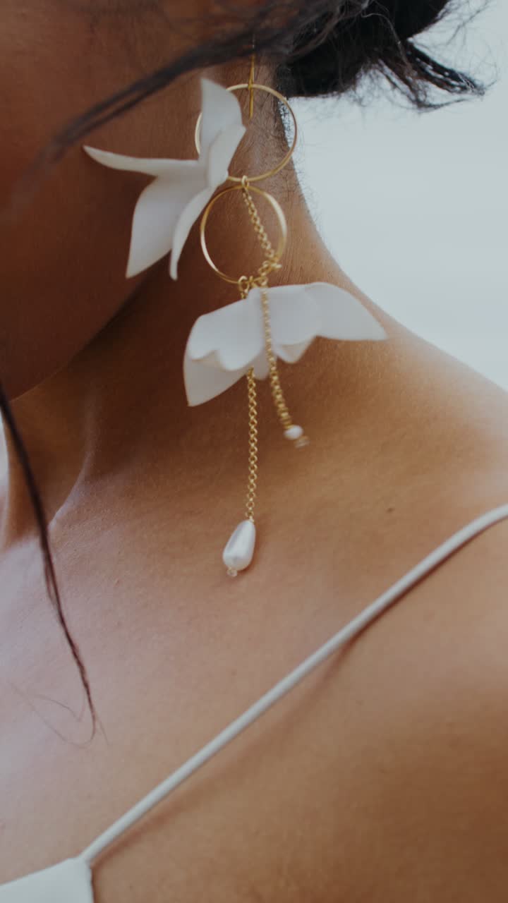 Close-up of a woman in a wedding dress with flower earrings