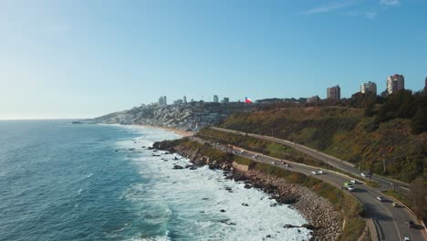 Aerial-view-rising-above-sunny-Reñaca-scenic-tourist-coastal-hotel-resort-buildings-along-Vina-Del-Mar-seascape