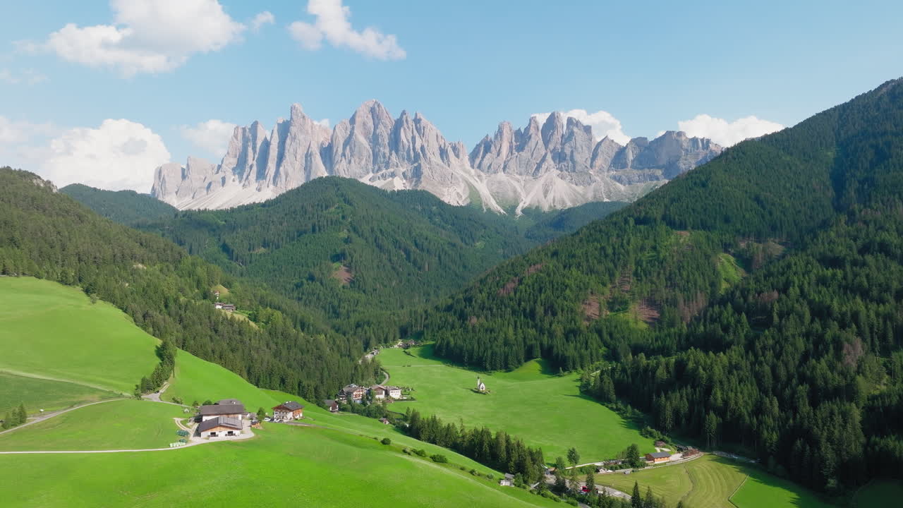 Aerial view of the idyllic Church of St. John nestled in the blossoming landscape of the Italian Dolomites during spring