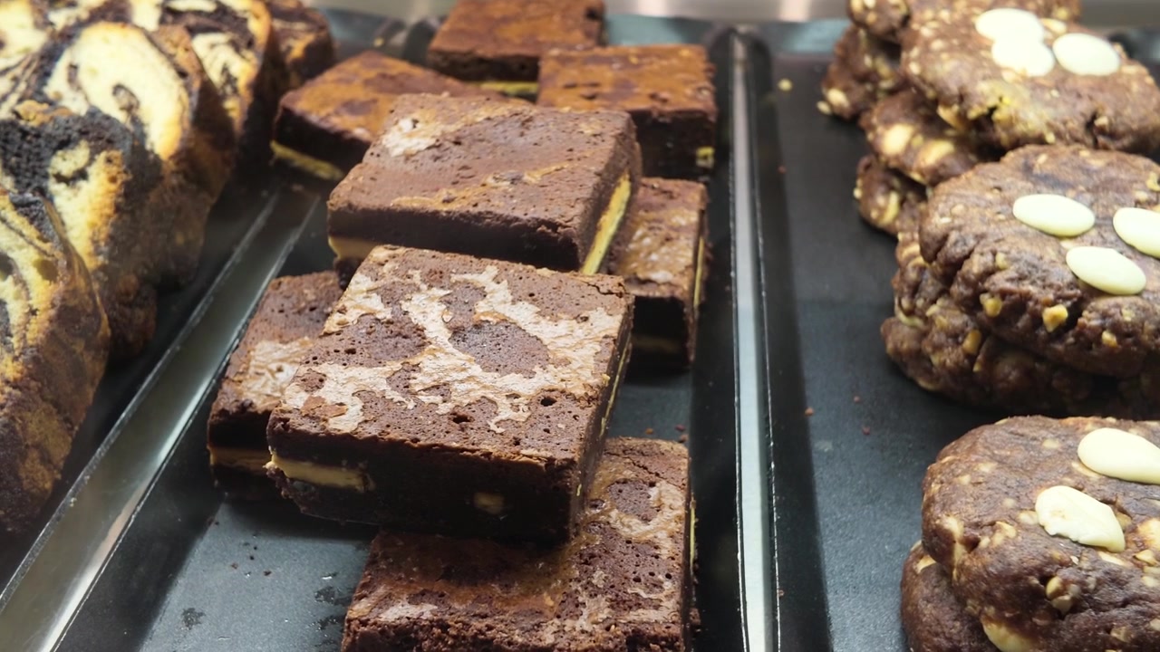 Assortment of Freshly Baked Brownies and Cookies in a Bakery Display Case