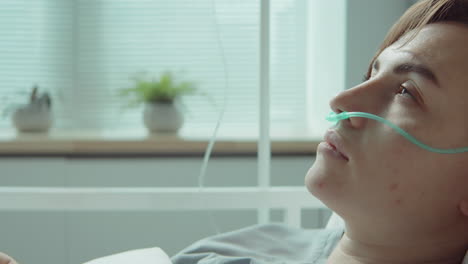 female patient with nasal cannula lying on hospital bed