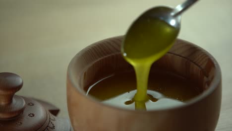 Thick-honey-dripping-from-the-spoon,-close-up.-Honey-flowing-honey-from-a-spoon