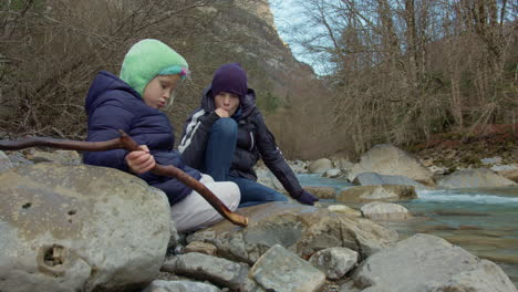 mother and daughter hiking by a river