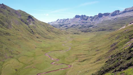 gran río sinuoso entre las enormes montañas apenas vegetadas en el valle de hecho y cerca de huesca en españa en un caluroso día de verano
