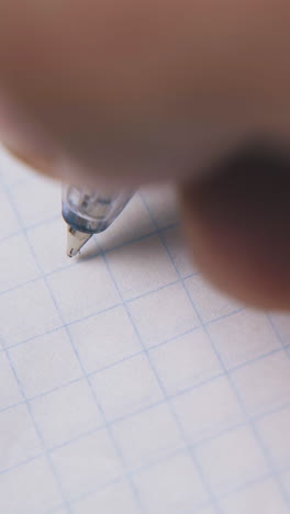 person writes words stop it with ball pen on blank checkered paper sheet and puts signature extreme close view