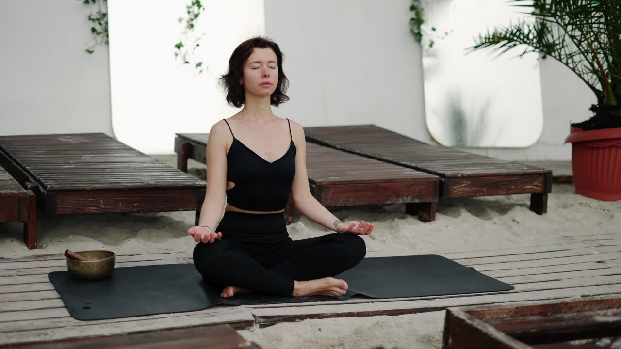 mujer relajada haciendo yoga asana meditación en la playa