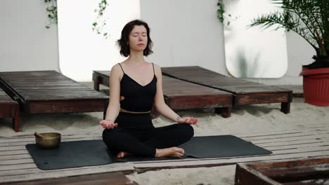 relaxful woman doing yoga asana meditation on the beach