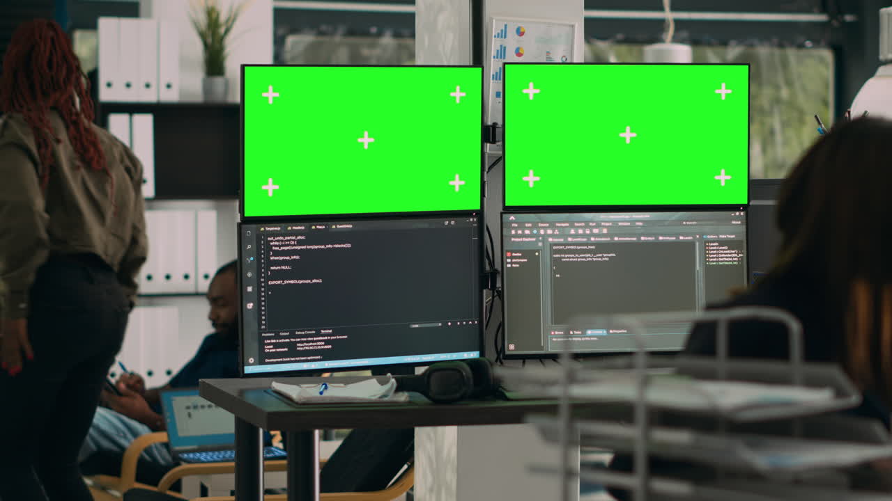 Database developer analyzing greenscreen display on multiple screens