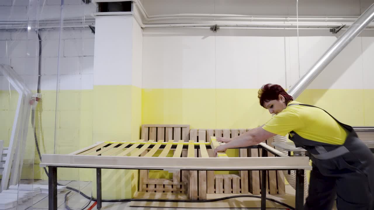 mujer montando un marco de cama en un taller