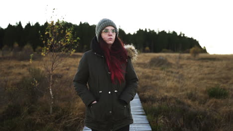 Portrait-of-woman-walking-through-marshland,-slow-motion-view