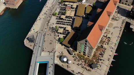 Aerial-Flyover-Shot-of-A-Busy-Bike-Bridge-in-Copenhagen-Next-To-The-Harbour