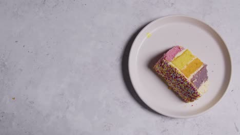 fotografía cenital de una rebanada cortada del pastel de celebración del arco iris en un plato