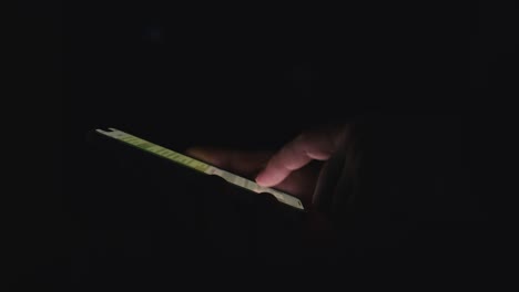 persona que utiliza un teléfono inteligente por la noche