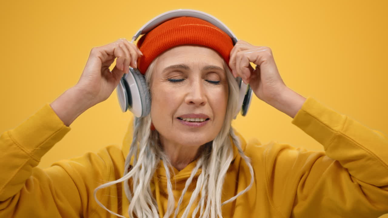 una mujer anciana alegre bailando en un estudio moderno. una mujer alegre relajándose en el interior.
