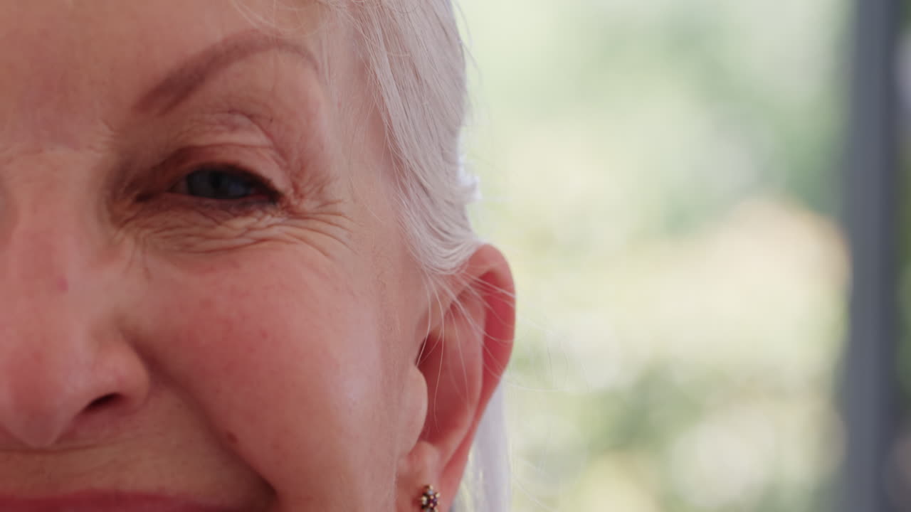 Close-up of senior woman smiling warmly, enjoying peaceful moment at home, copy space