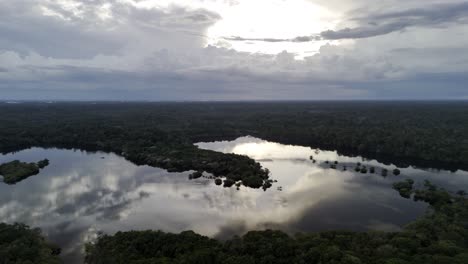 epic sunset over beautiful amazon river, moody sky, aerial establishing wide, slowly tracking left