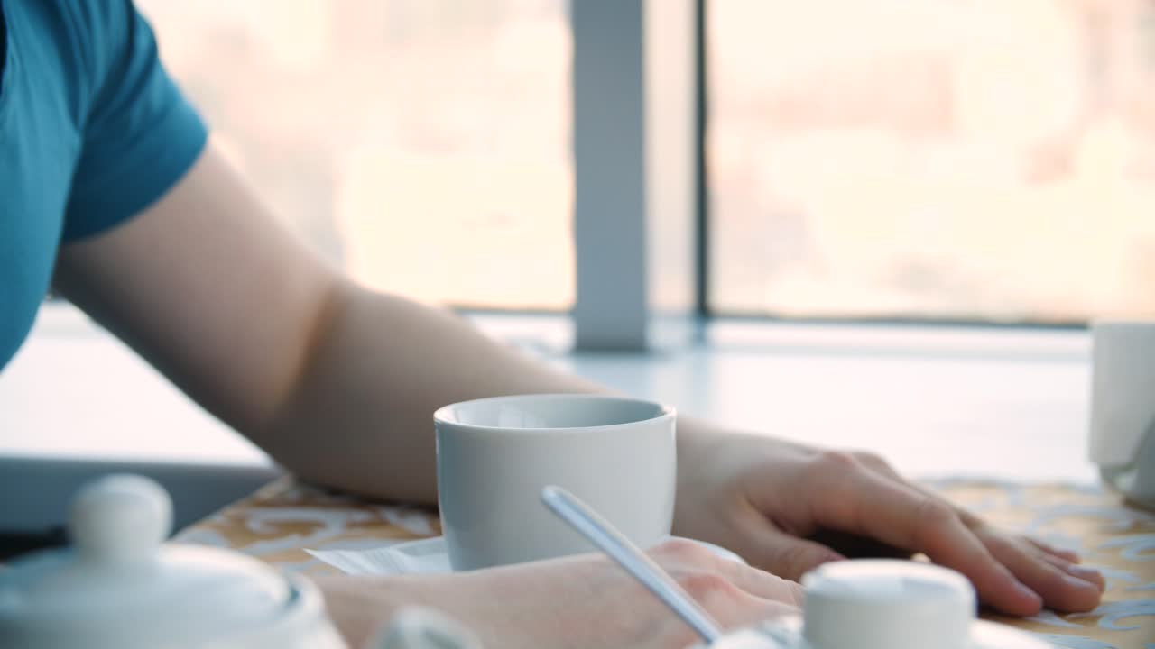 커피를 마시고 카페에서 노트에 글을 쓰는 사람