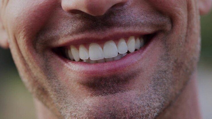 Primo piano di un uomo sorridente che mostra denti bianchi
