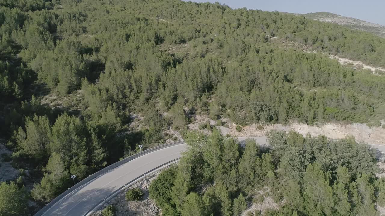 Aerial shot of roller skater downhill on a mountain road