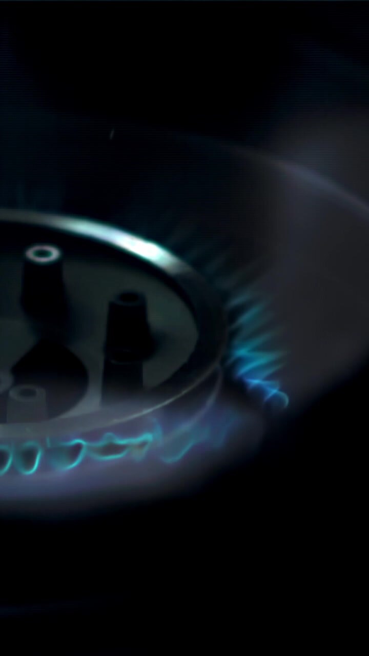 Close-up of a Gas Stove Burner Igniting with Blue Flame