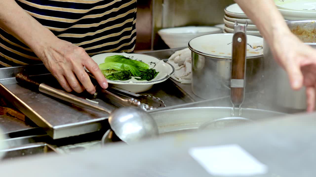 Chef prepares noodle soup with fresh ingredients