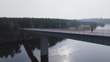 El-Dron-Se-Desliza-De-Lado-Y-Captura-Un-Puente-Lleno-De-Peatones-Que-Conecta-La-Ciudad-Con-El-Bosque.