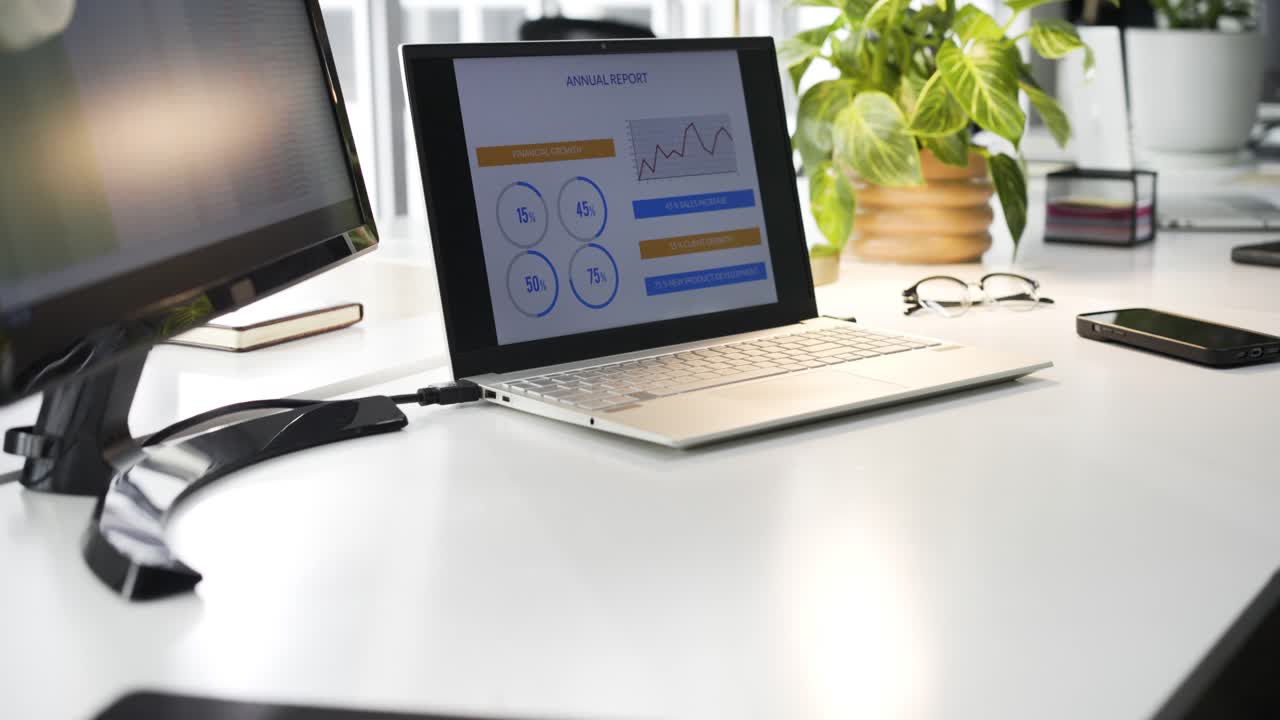 Camera is starting on desk and panning right to reveal laptop displaying report percentages