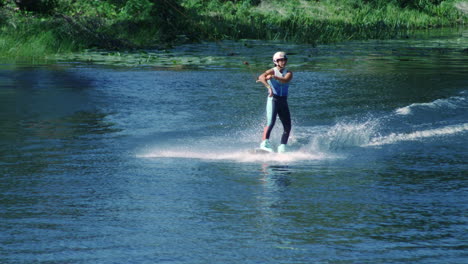 Pretty-girl-wakeboarding-on-summer-river.-Woman-practicing-water-skiing