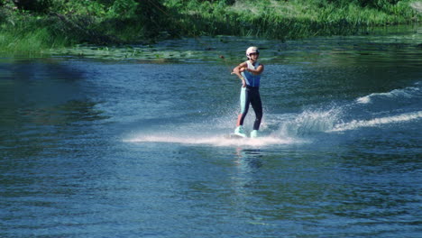 pretty girl wakeboarding on summer river. woman practicing water skiing