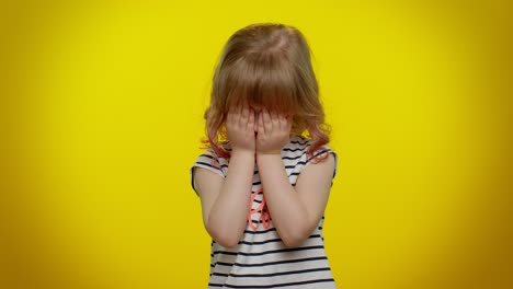 nosy curious child girl closing eyes with hand and spying through fingers, hiding, peeping, seeking