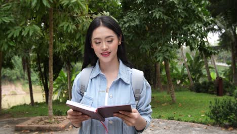 asian woman student walking and reading a book, video in 4k