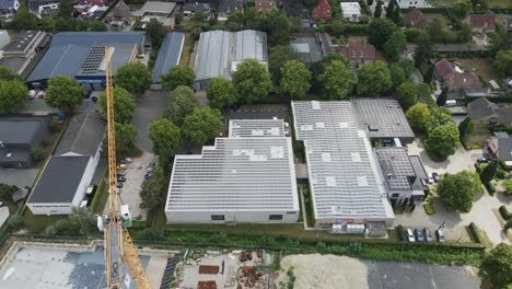 beautiful aerial orbit of photovoltaic solar panels on thee rooftops of newly built industrial building on a sunny day