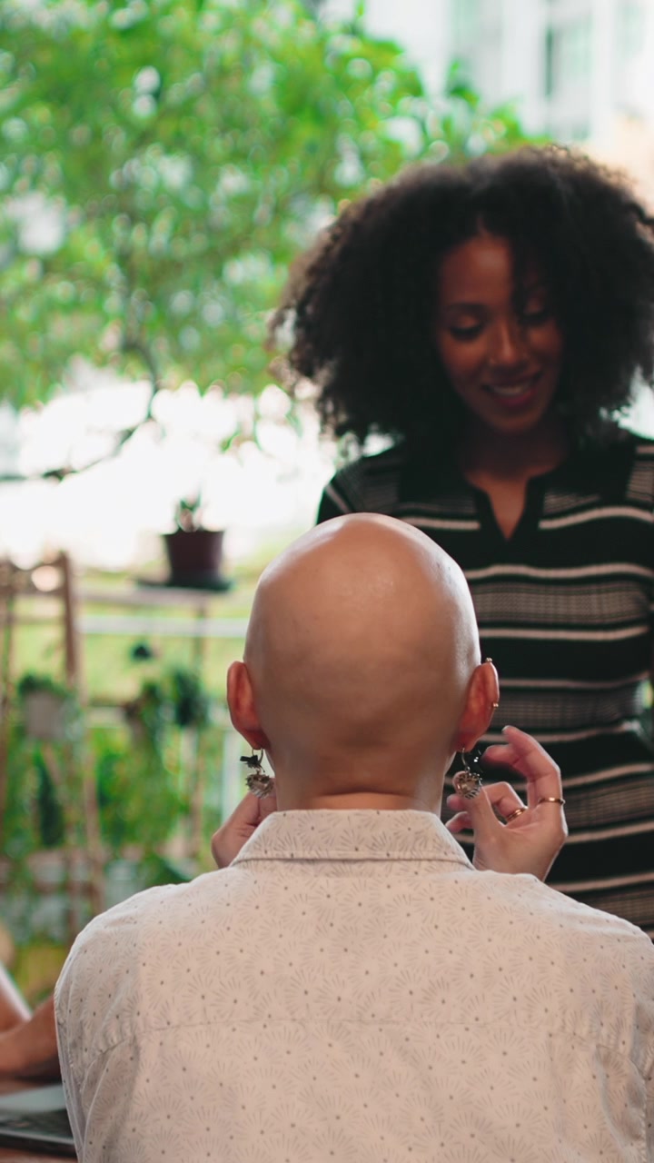 Person Trying On Decorative Earrings While Friend Watches