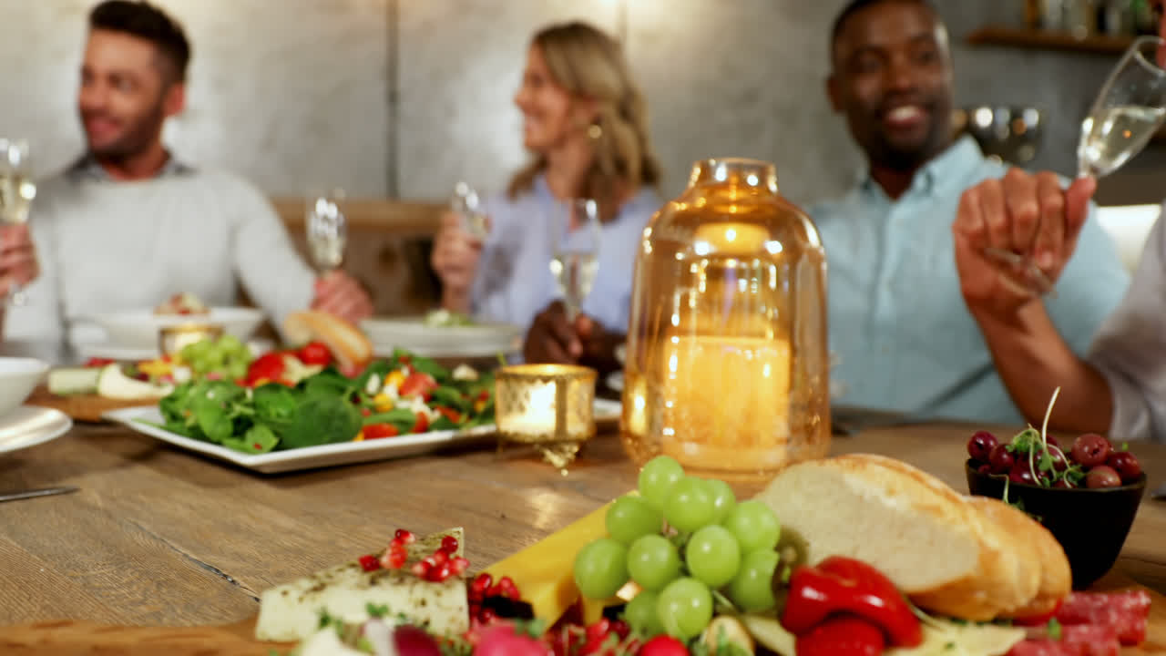 저녁 식사 테이블에서  ⁇ 페인을 마시는 친구들의 그룹 4k 4k